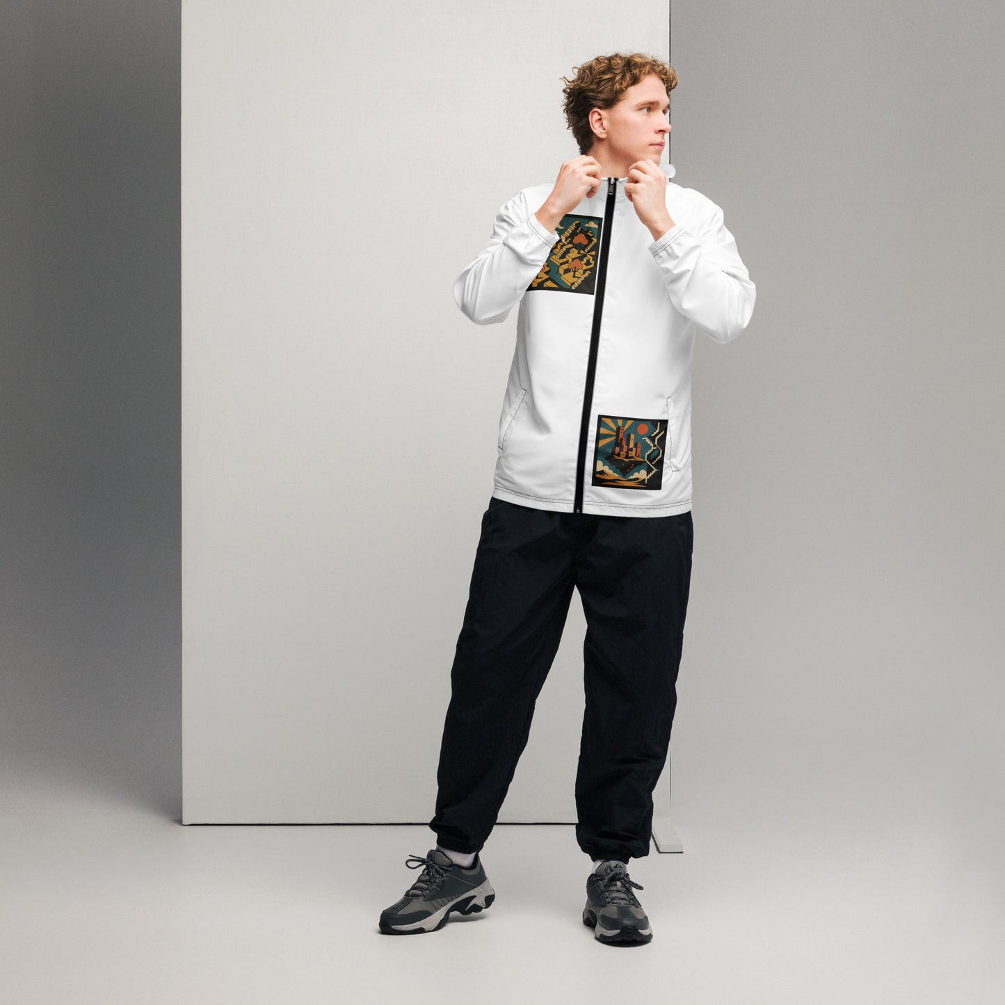 Person wearing a white jacket with colorful patterns and black pants on a gray background