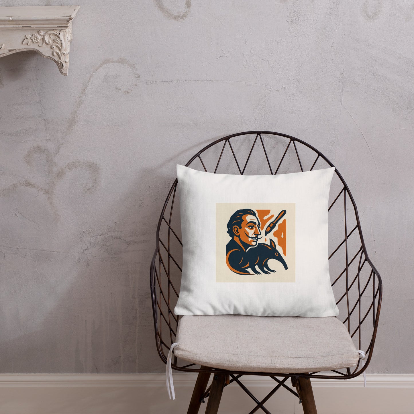 White pillow with a graphic design on a black wire chair against a gray wall.