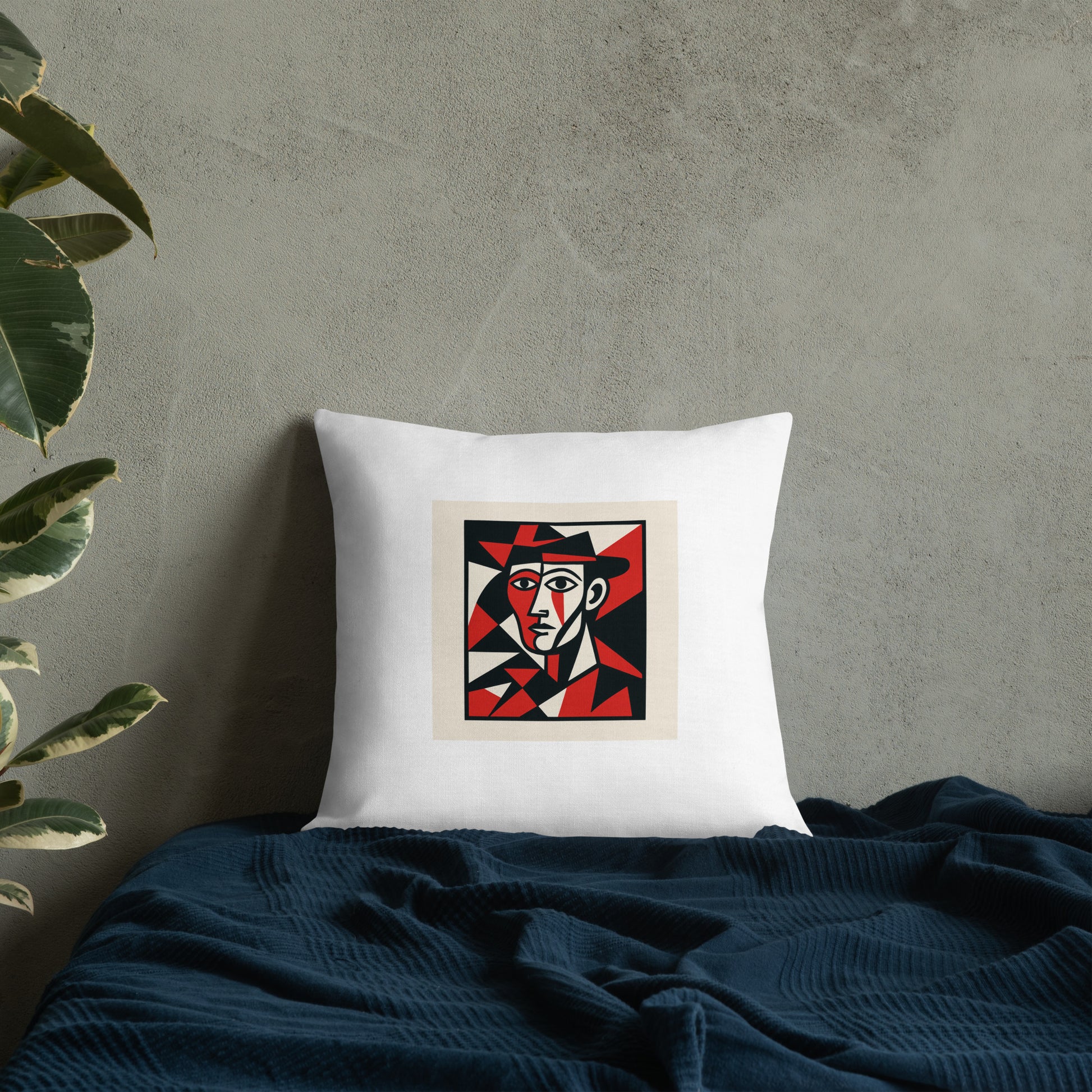 White pillow with a colorful abstract design on a gray wall with a plant.