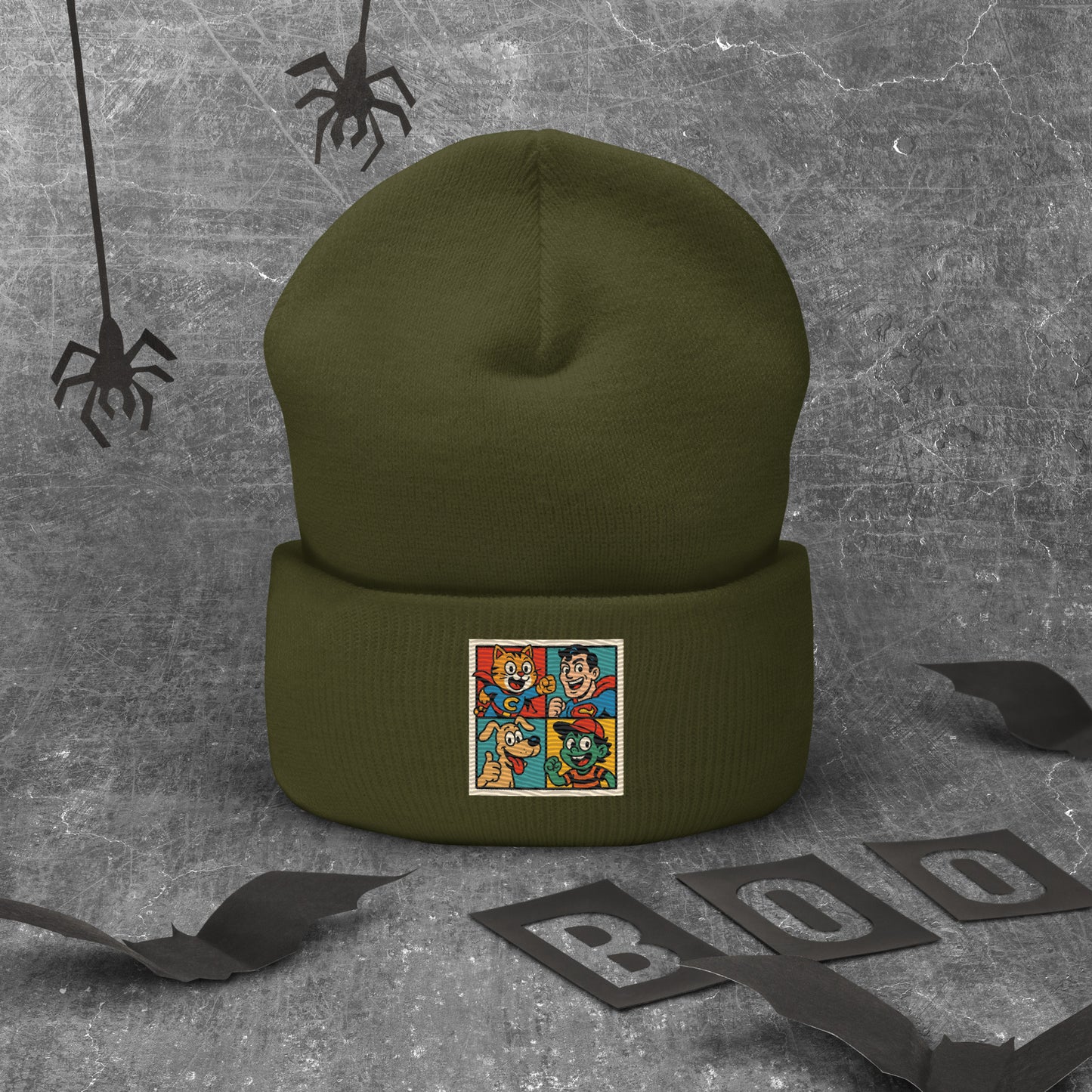 Green beanie with a colorful graphic on a textured gray background with Halloween decorations.