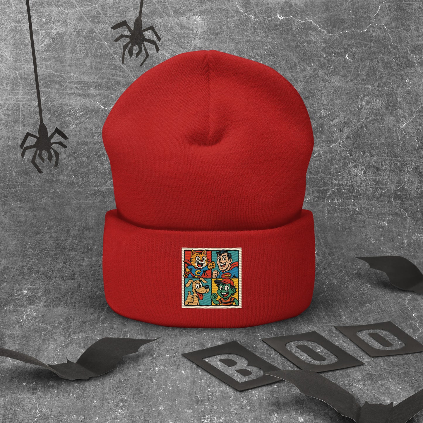 Red beanie with a colorful graphic on a gray textured background with spider decorations.