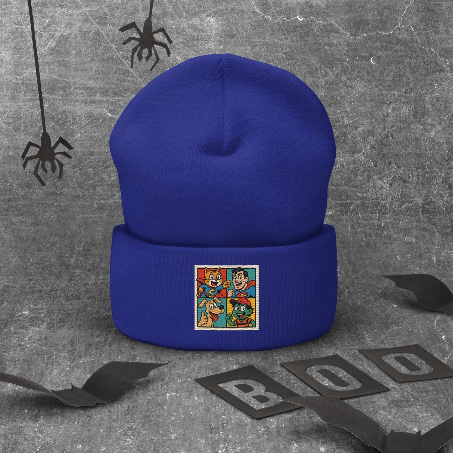 Blue beanie with a colorful patch on a gray background with spider decorations.