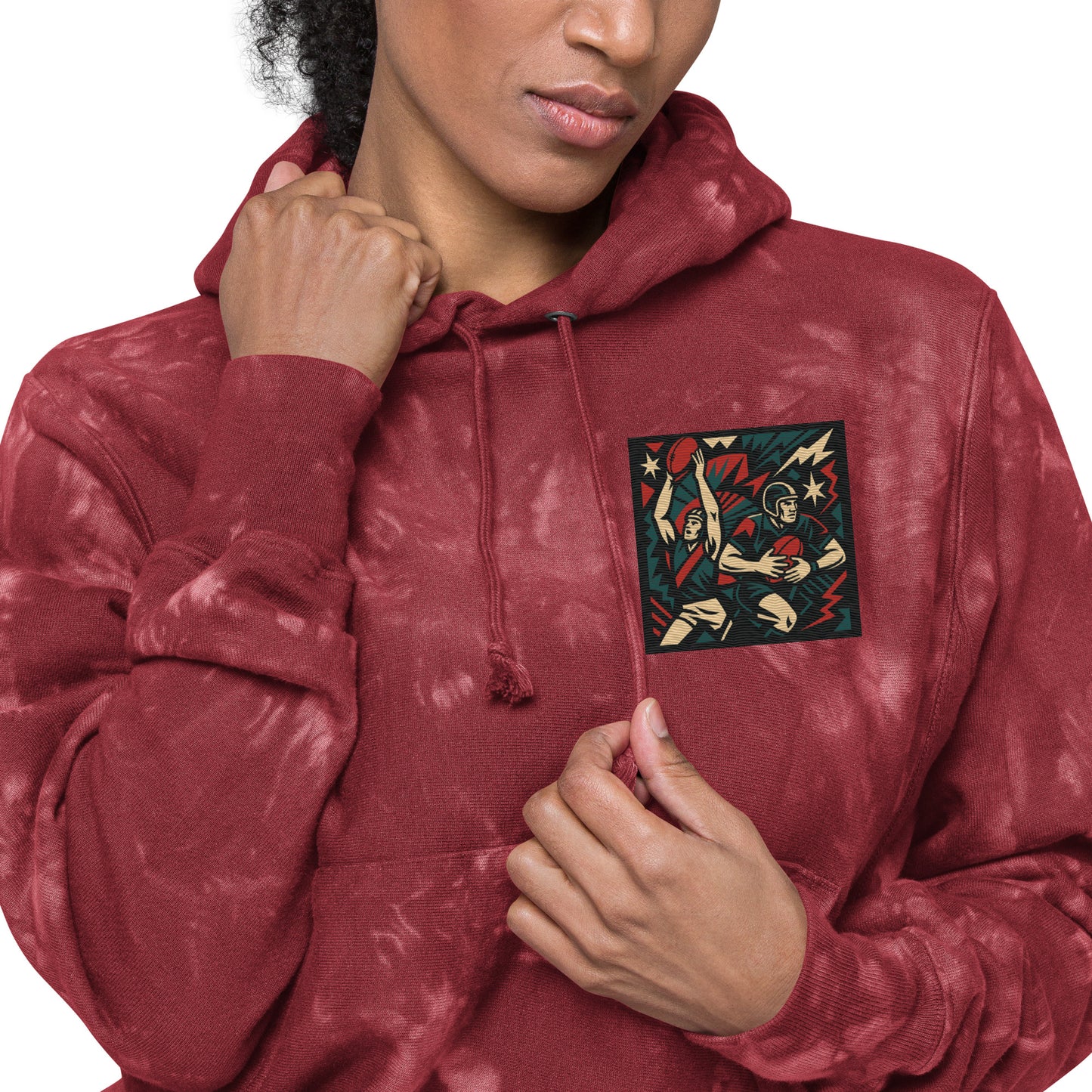 Person wearing a maroon tie-dye hoodie with a graphic design on the chest.