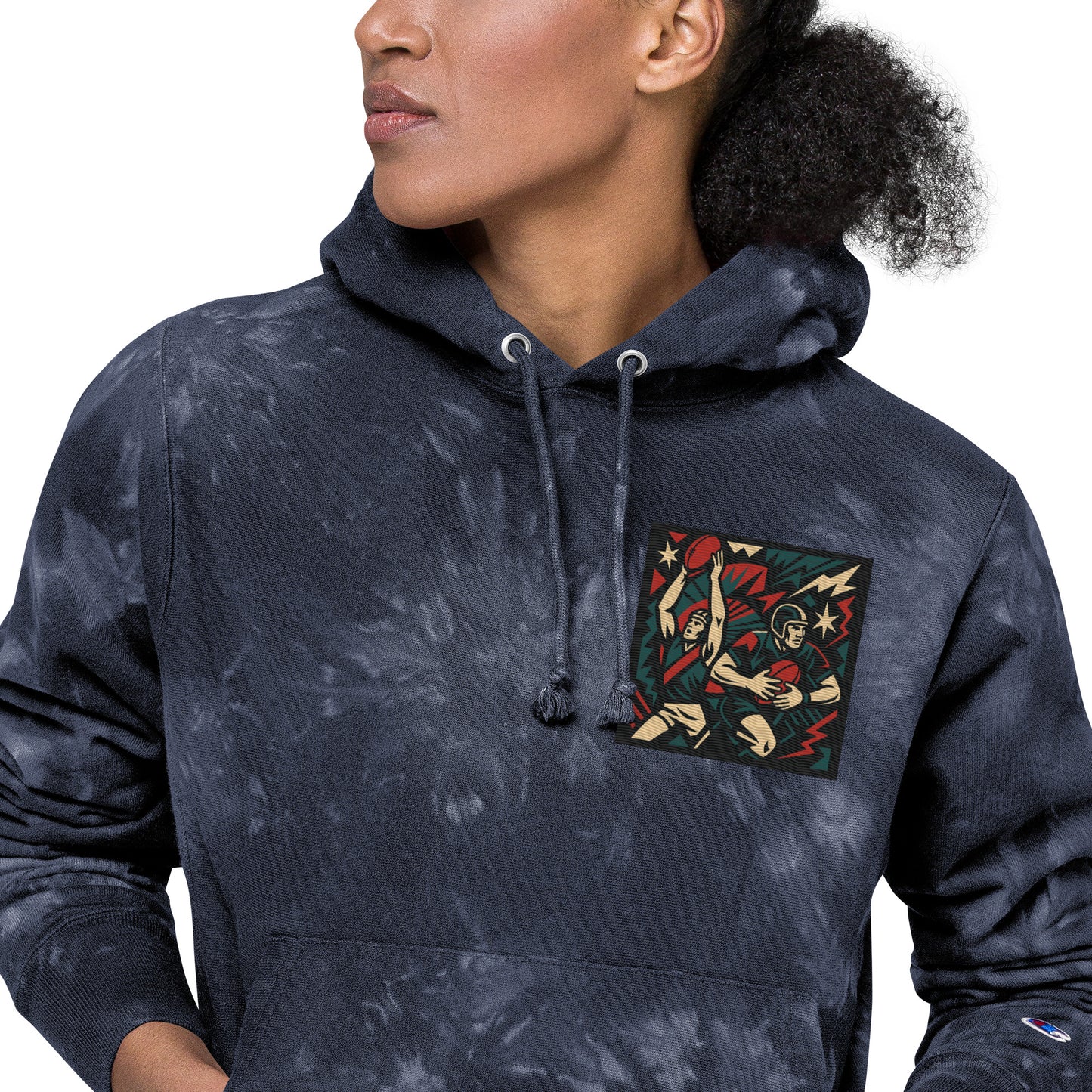 Person wearing a navy tie-dye hoodie with a colorful graphic on the chest pocket against a white background
