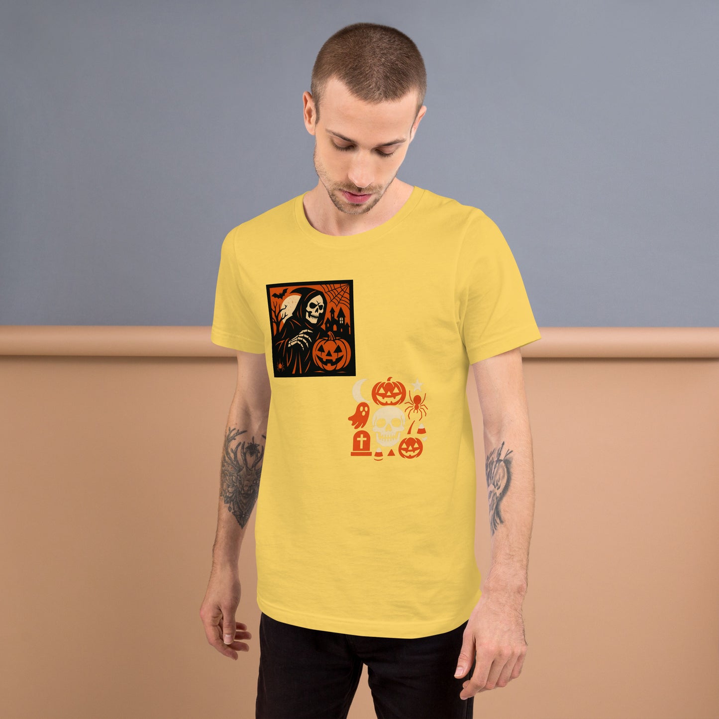 Man wearing a yellow t-shirt with Halloween-themed graphics against a plain background