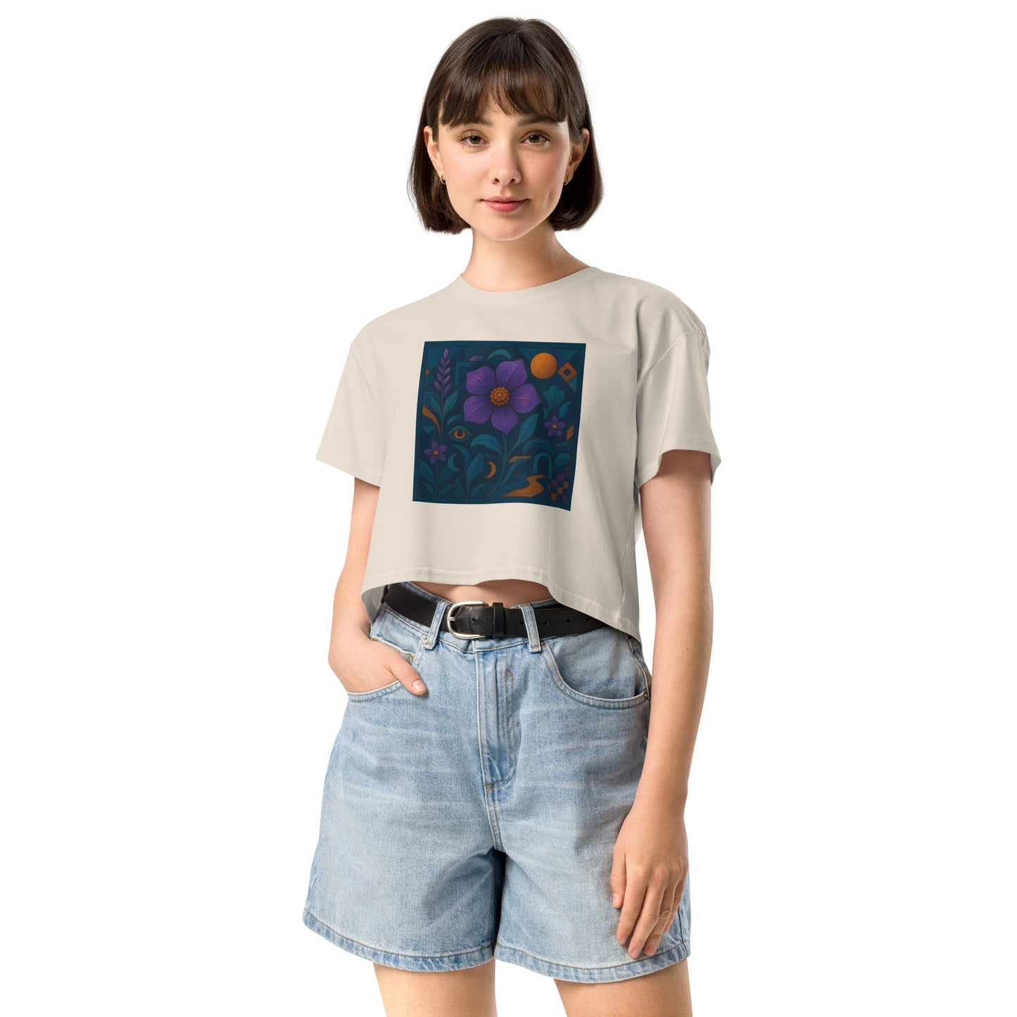 Person wearing a beige t-shirt with a colorful flower design and denim shorts on a white background