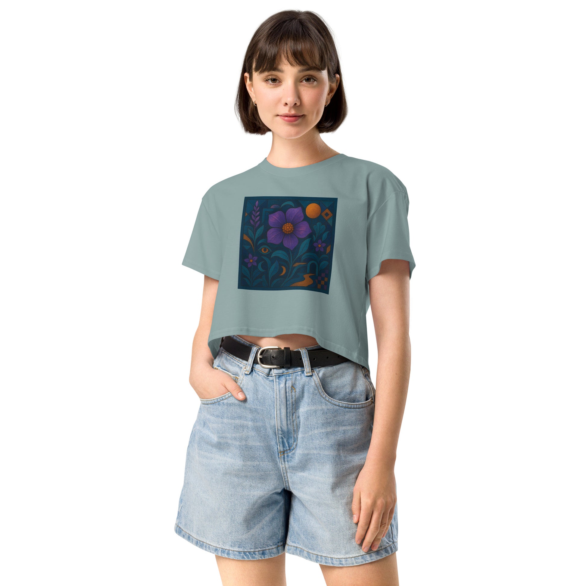 Person wearing a light blue t-shirt with a floral design and denim shorts on a white background