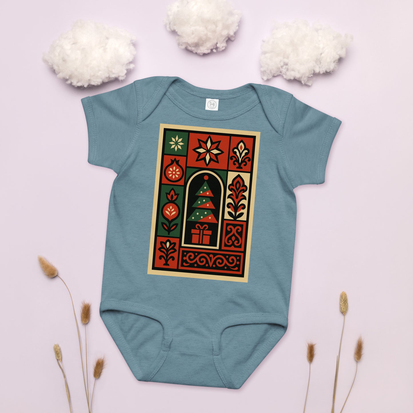 Teal baby onesie with a festive design on a light pink background with decorative elements.